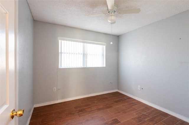 empty room featuring ceiling fan, dark wood-type flooring, and a textured ceiling