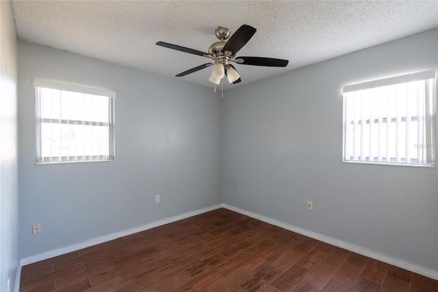 empty room featuring a textured ceiling, ceiling fan, and dark wood-type flooring