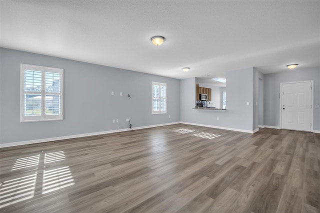 unfurnished living room featuring a textured ceiling and hardwood / wood-style flooring