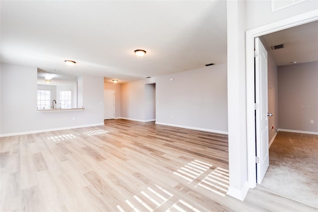 unfurnished living room featuring sink and light wood-type flooring