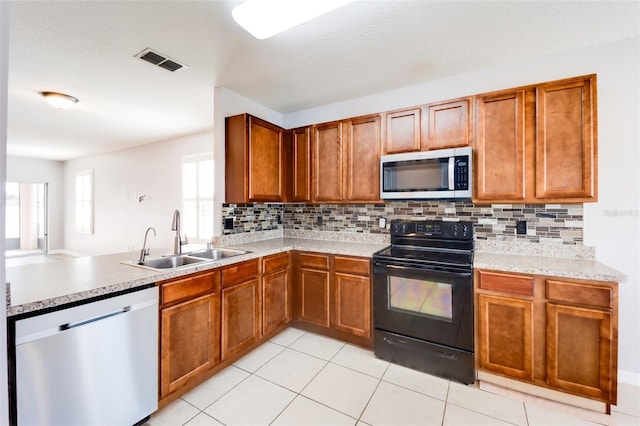 kitchen featuring appliances with stainless steel finishes, tasteful backsplash, light tile patterned floors, and sink