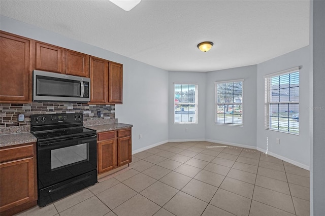 kitchen featuring decorative backsplash, light tile patterned floors, a textured ceiling, and black range with electric cooktop