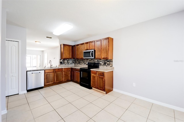 kitchen featuring decorative backsplash, appliances with stainless steel finishes, light tile patterned floors, and sink