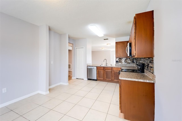 kitchen with decorative backsplash, a textured ceiling, stainless steel appliances, sink, and light tile patterned floors