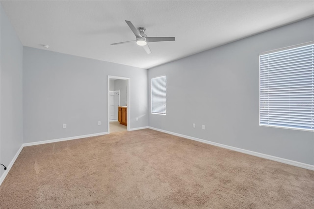 unfurnished room featuring ceiling fan, plenty of natural light, and light carpet