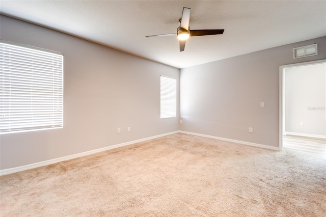 carpeted spare room with ceiling fan