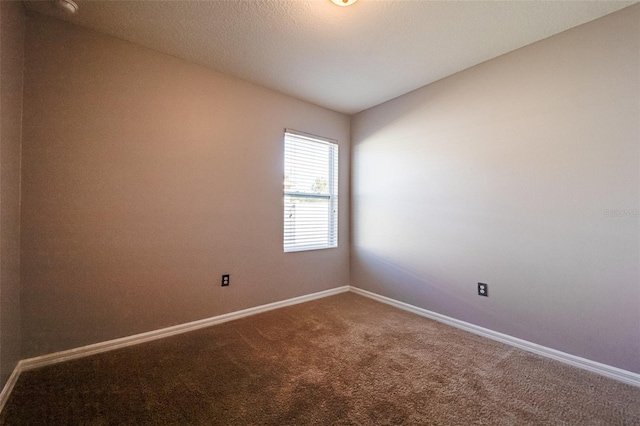 spare room featuring carpet and a textured ceiling