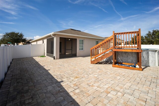 rear view of house featuring a sunroom and a patio