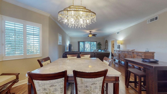 dining space featuring ceiling fan with notable chandelier, wood-type flooring, and ornamental molding