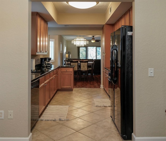 kitchen featuring kitchen peninsula, a textured ceiling, ceiling fan with notable chandelier, black appliances, and light tile patterned flooring