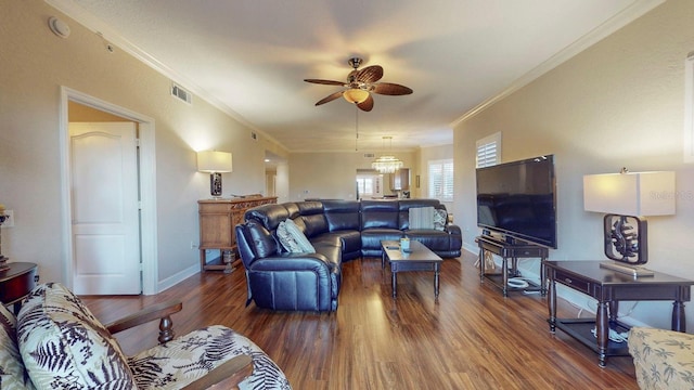 living room with dark hardwood / wood-style floors, crown molding, and ceiling fan with notable chandelier