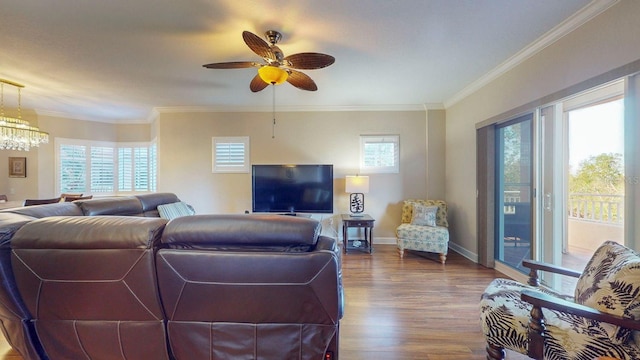 living room with ceiling fan with notable chandelier, wood-type flooring, and crown molding