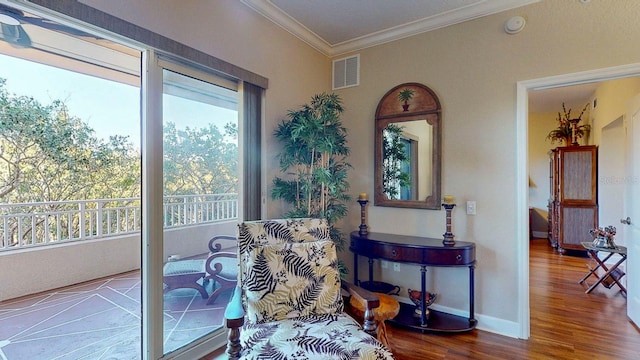 living area with crown molding and hardwood / wood-style flooring