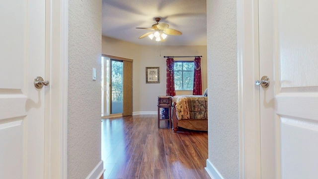 corridor featuring dark hardwood / wood-style flooring and a textured ceiling