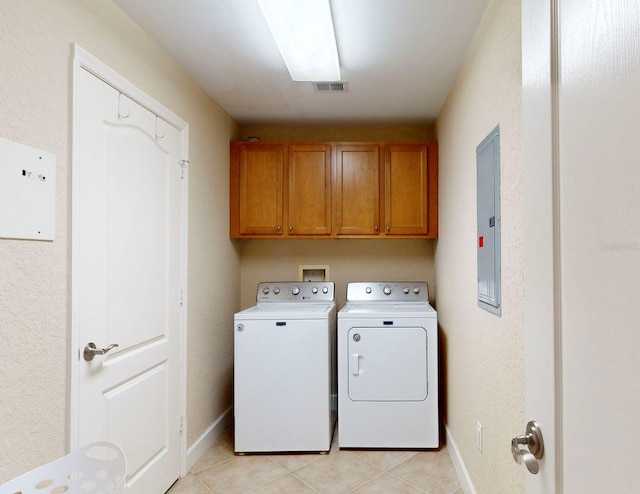 washroom featuring washer and dryer, light tile patterned flooring, and cabinets