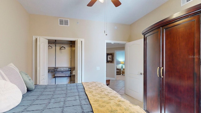 tiled bedroom featuring ceiling fan and a closet