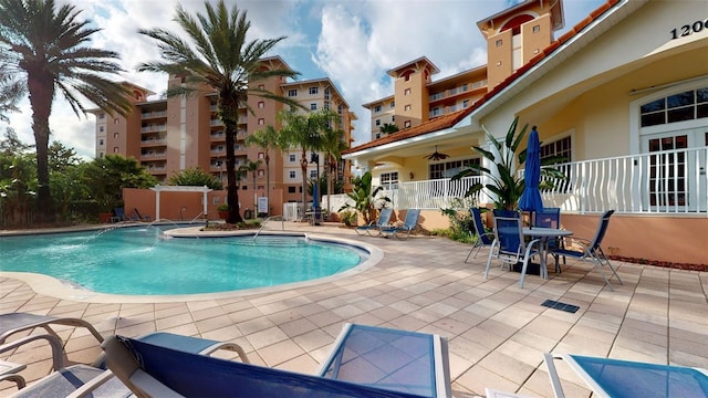 view of pool with ceiling fan, pool water feature, and a patio