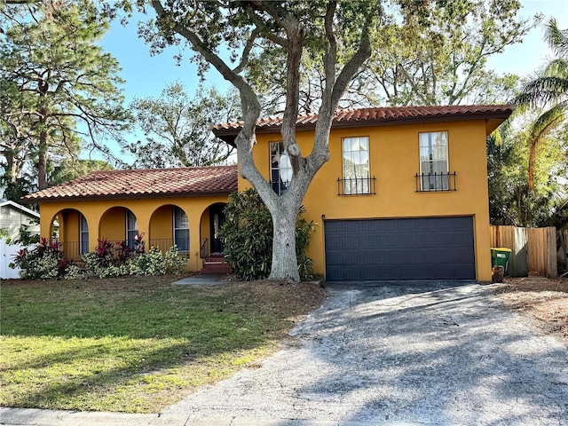 mediterranean / spanish-style house featuring a front yard and a garage