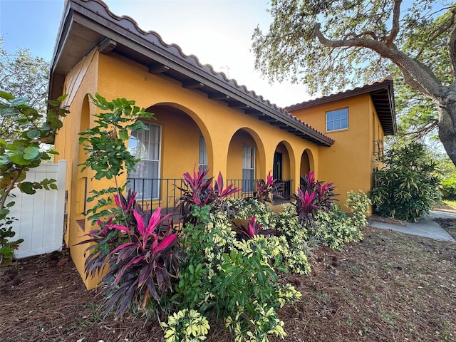 view of side of property featuring covered porch