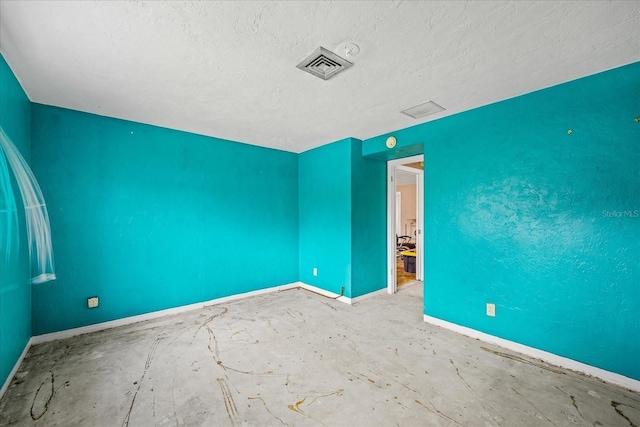 unfurnished room with a textured ceiling