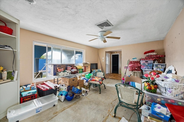 interior space featuring ceiling fan, concrete floors, and a textured ceiling