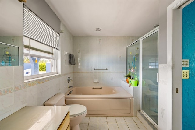 full bathroom with tile patterned floors, toilet, vanity, independent shower and bath, and tile walls