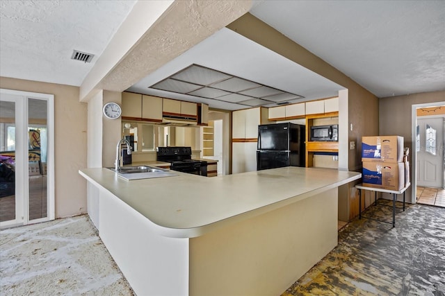 kitchen with kitchen peninsula, sink, and black appliances