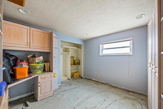 interior space with light brown cabinets and a textured ceiling