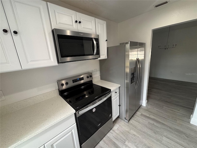 kitchen featuring light hardwood / wood-style flooring, white cabinets, and appliances with stainless steel finishes