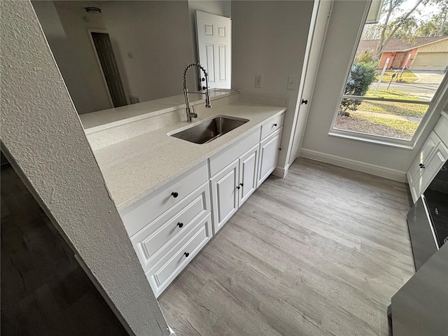 kitchen featuring sink, white cabinets, and light hardwood / wood-style floors