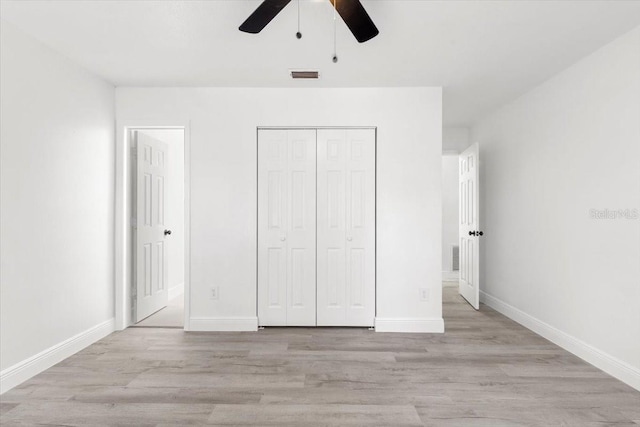 unfurnished bedroom featuring light hardwood / wood-style flooring, a closet, and ceiling fan