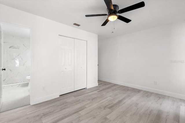 unfurnished bedroom featuring ensuite bathroom, a closet, ceiling fan, and light hardwood / wood-style flooring