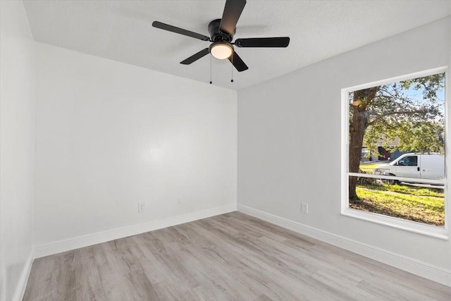 empty room with ceiling fan and light hardwood / wood-style floors