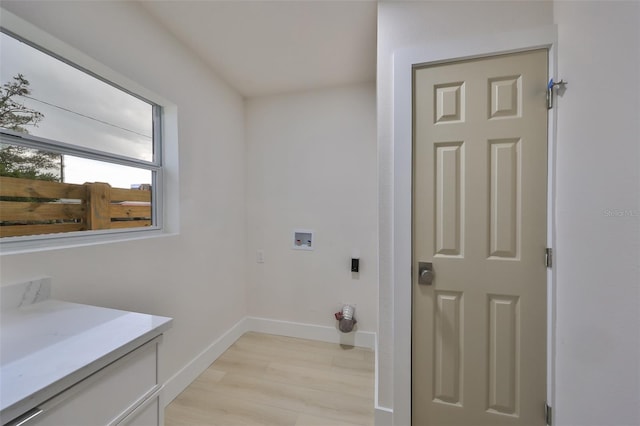 washroom with hookup for a washing machine and light hardwood / wood-style flooring