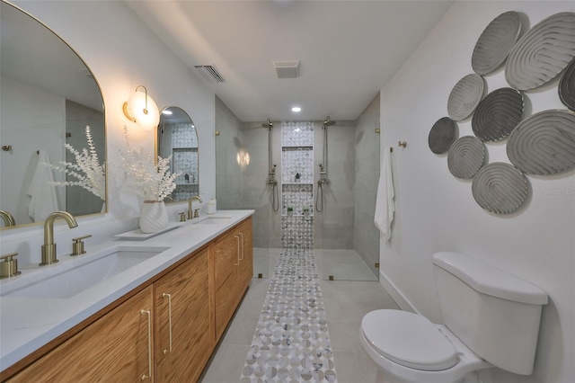 bathroom featuring tile patterned floors, vanity, toilet, and a tile shower