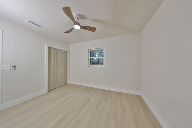 unfurnished bedroom with ceiling fan, light wood-type flooring, and a closet