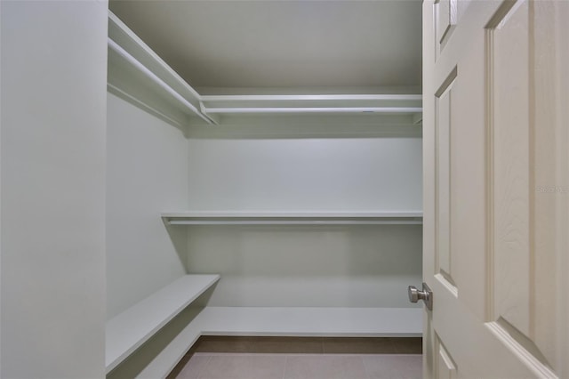 walk in closet with light tile patterned floors