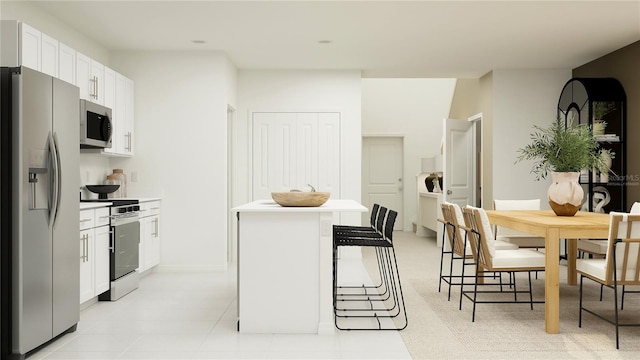 kitchen featuring a kitchen island, stainless steel appliances, white cabinetry, and a breakfast bar area