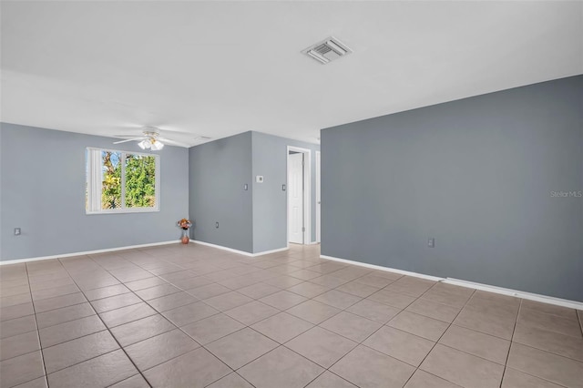 empty room with ceiling fan and light tile patterned flooring