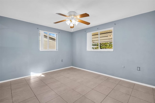 empty room with ceiling fan and light tile patterned floors