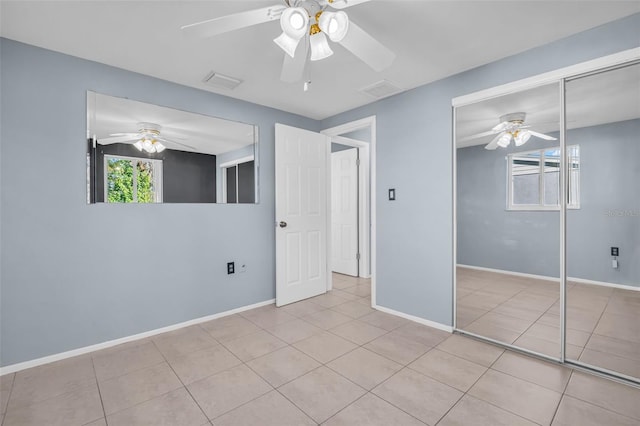 unfurnished bedroom featuring ceiling fan, light tile patterned floors, and a closet