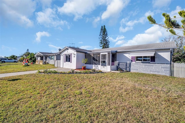 ranch-style home with a front lawn and a sunroom