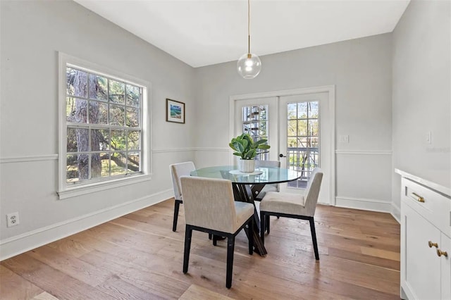 dining space featuring french doors, light hardwood / wood-style flooring, and a healthy amount of sunlight