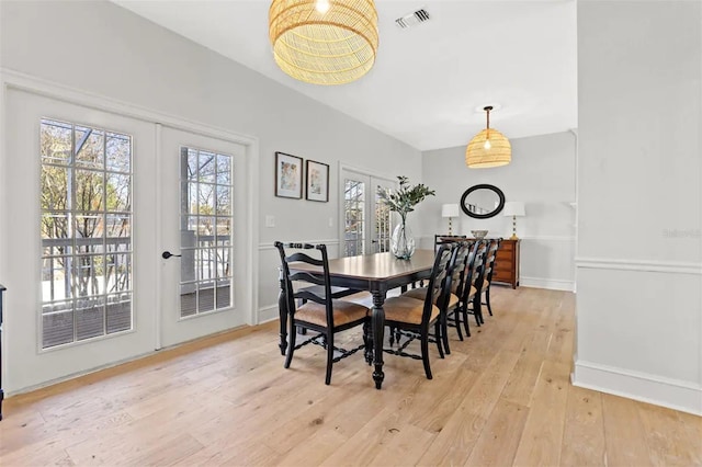 dining space with french doors and light hardwood / wood-style floors