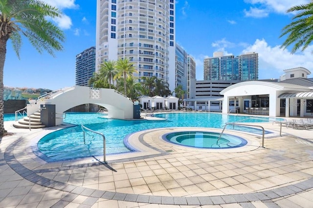 view of pool featuring a hot tub and a patio area