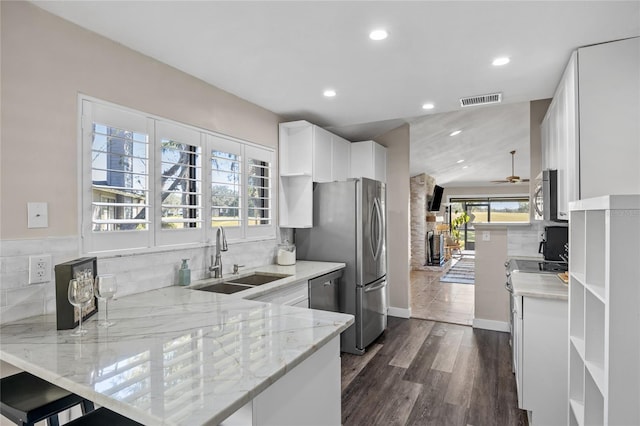 kitchen featuring kitchen peninsula, white cabinets, a healthy amount of sunlight, and dark hardwood / wood-style floors