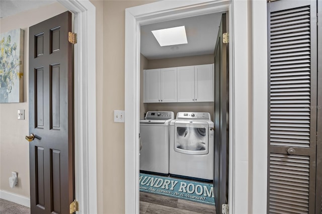 washroom with separate washer and dryer, cabinets, wood-type flooring, and a skylight