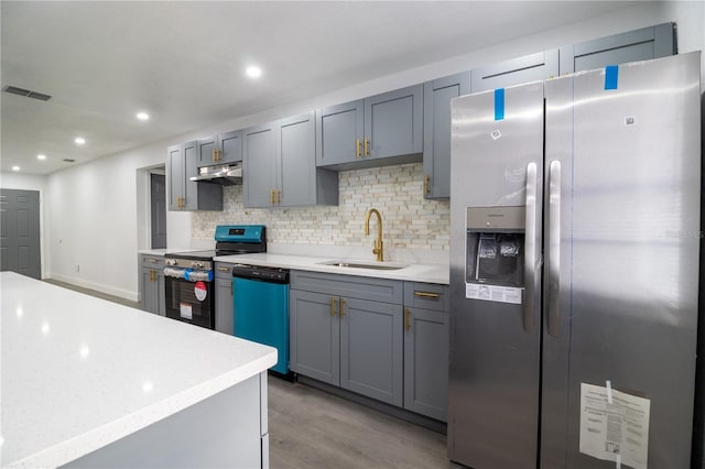 kitchen featuring decorative backsplash, gray cabinets, sink, and stainless steel appliances