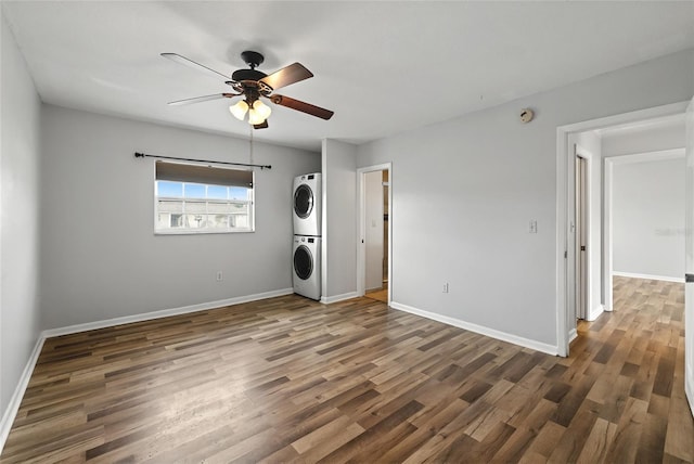 laundry room featuring ceiling fan, dark hardwood / wood-style flooring, and stacked washer and clothes dryer