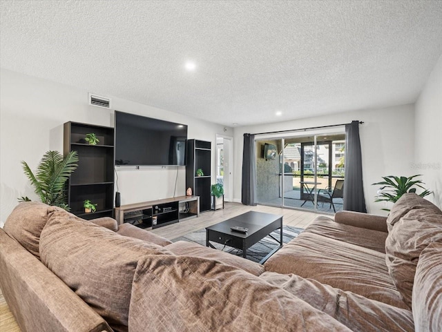 living room with a textured ceiling and light hardwood / wood-style floors